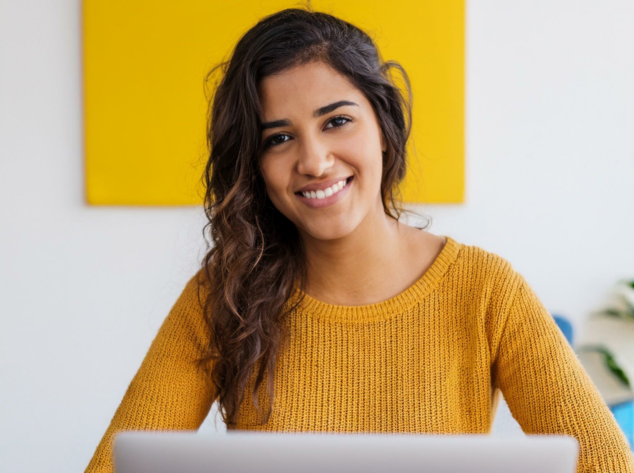 Smiling Young Woman Sitting At A Laptop